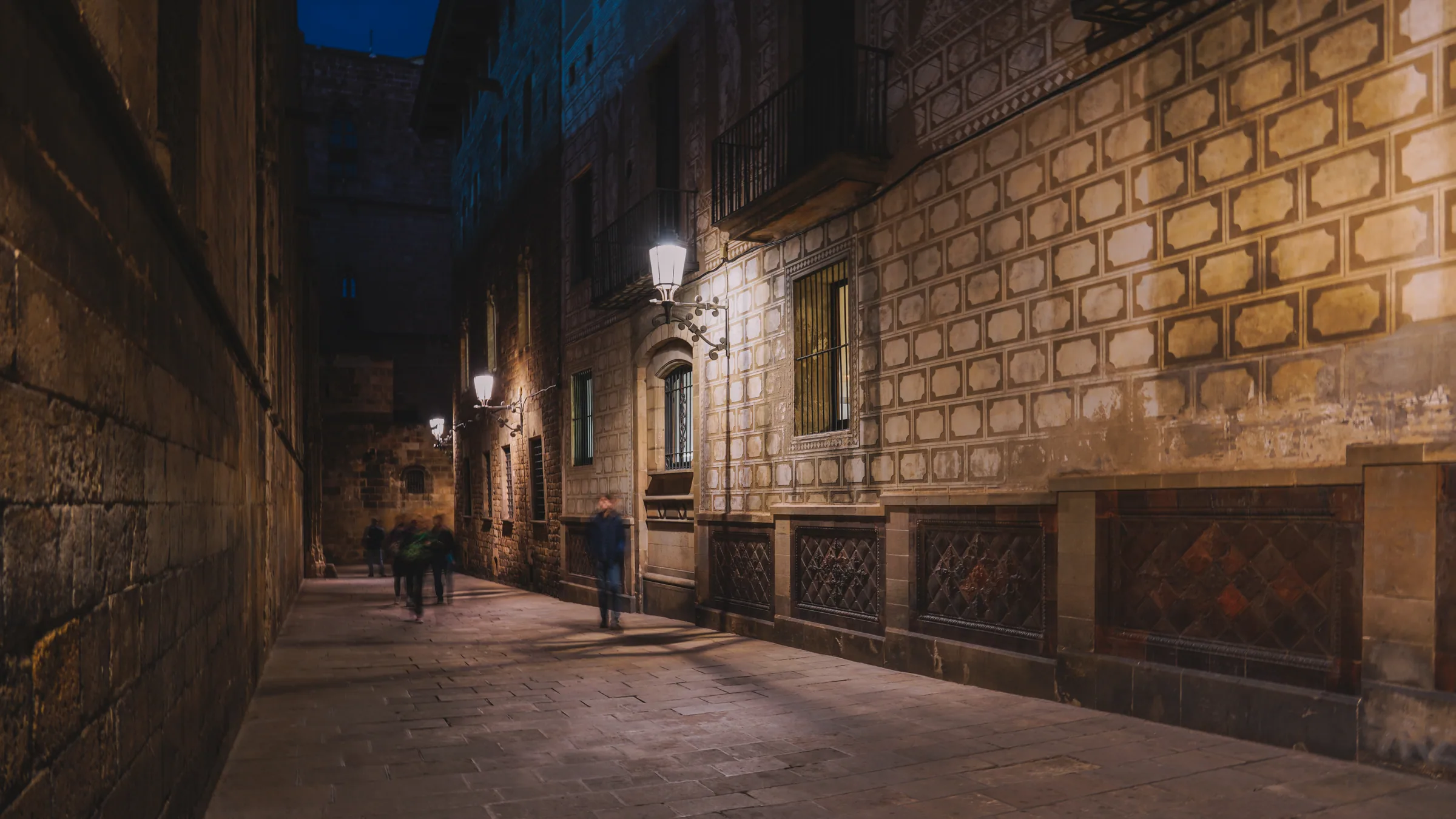 Best nights to go out in Barcelona — a lamp-lit lane in the Gothic Quarter at blue hour, Ciutat Vella, the postcode that holds 17 of the city's revealed nightlife rooms and five of its clubs