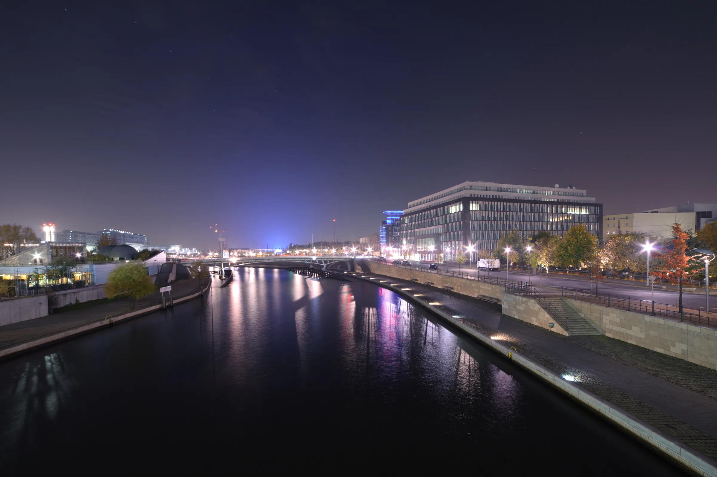Best nights to go out in Berlin — the Spree at night from a Mitte bridge, streetlights on the water and the government-quarter bank running down toward Schiffbauerdamm