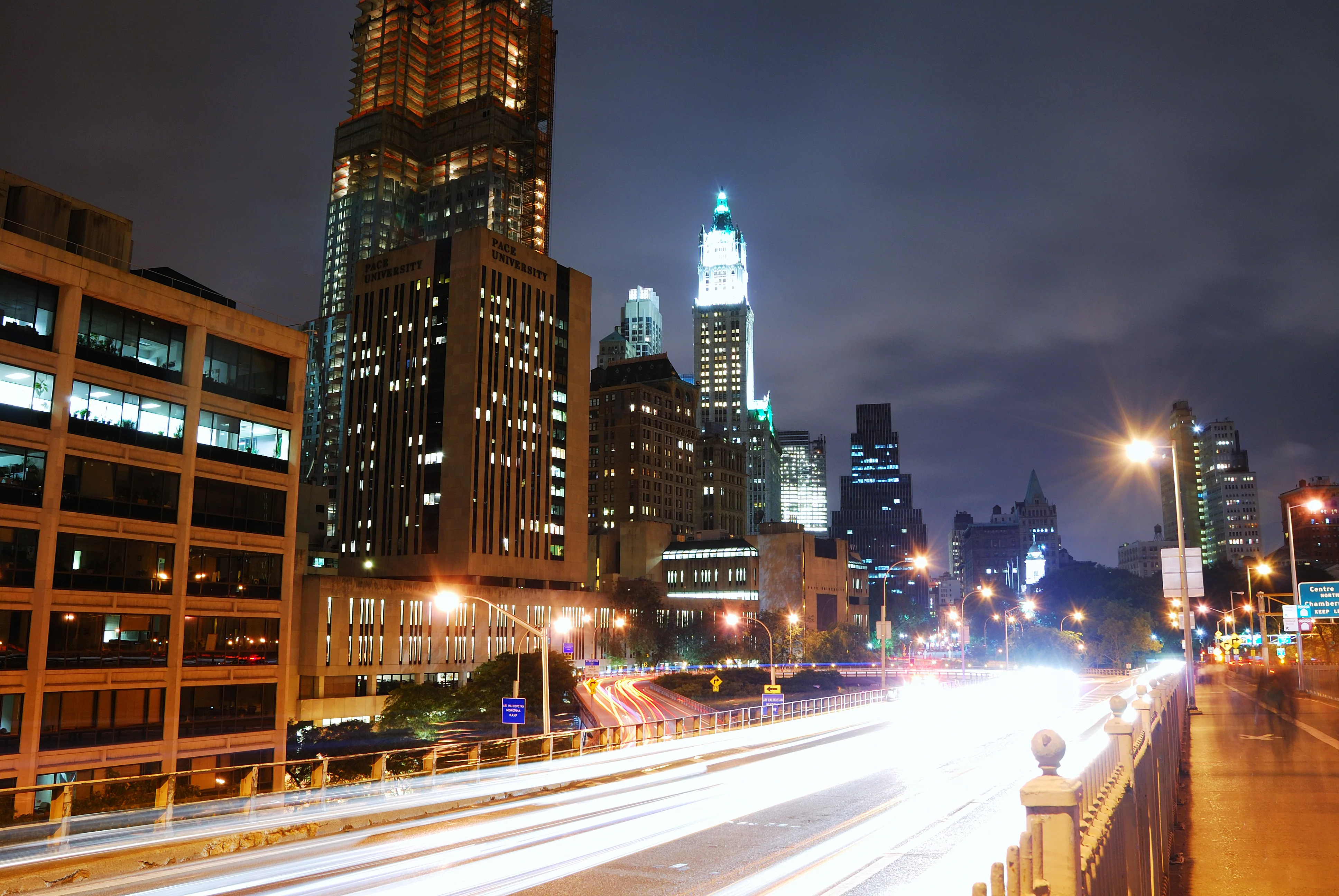 Best nights to go out in New York — Lower Manhattan lit up at night, Woolworth Building over the Brooklyn Bridge approach
