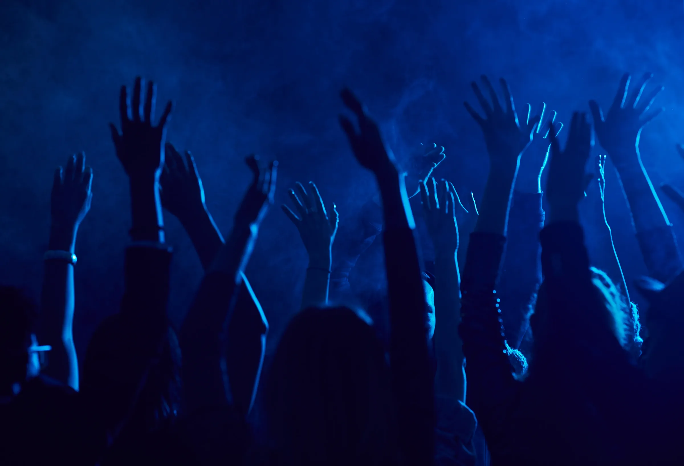 A crowd dancing in a nightclub under moving lights — the sound of a room you can hear before you go