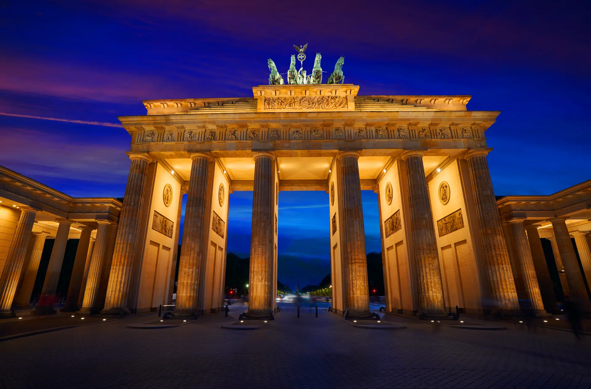 Bars in Berlin — the Brandenburg Gate lit at blue hour on Pariser Platz, steps from the Hotel Adlon lobby bar on Unter den Linden